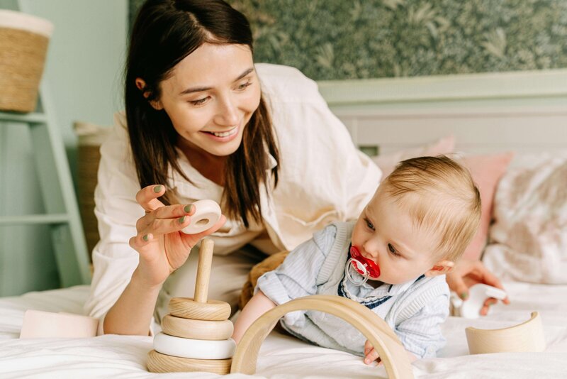 Mother playing with wooden blocks with her baby