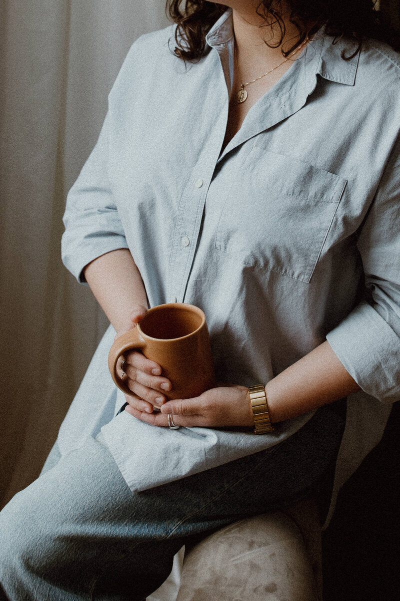 Loren Marshall LPC holding a coffee cup between hands