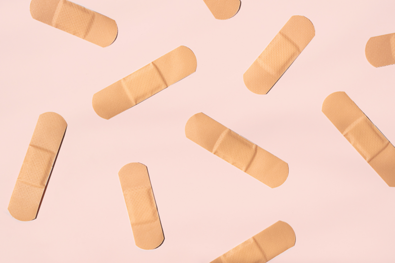 biege band-aids against a pink background