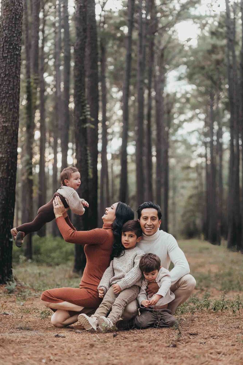 brothers run wild at a location in Houston with tall pine trees.