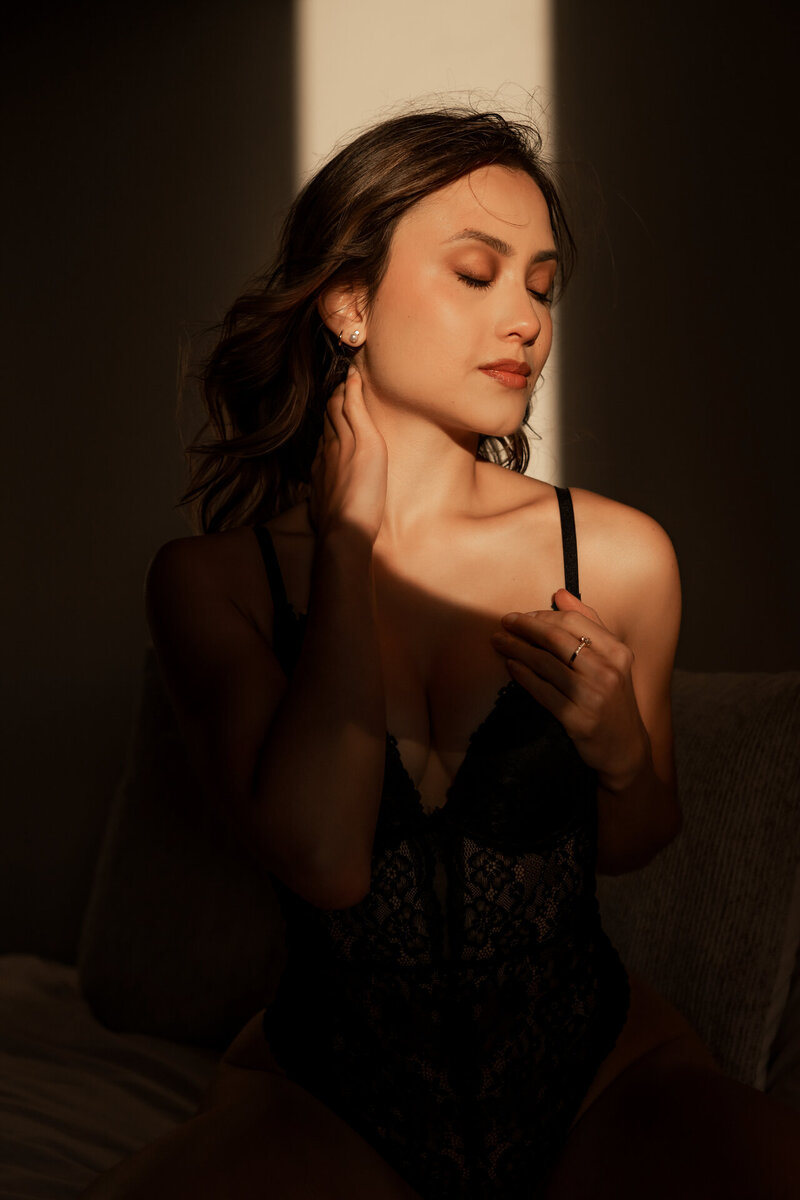 Boudoir foto van een vrouw die geniet van de warme zonnestralen op haar gezicht en de exclusieve beleving door Juliette Fotografie