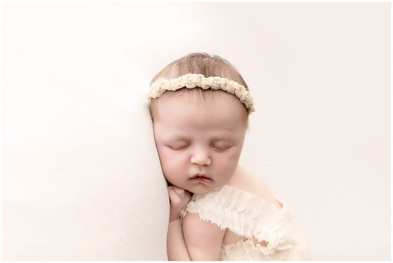 a newborn baby boy cozy in neutral layers