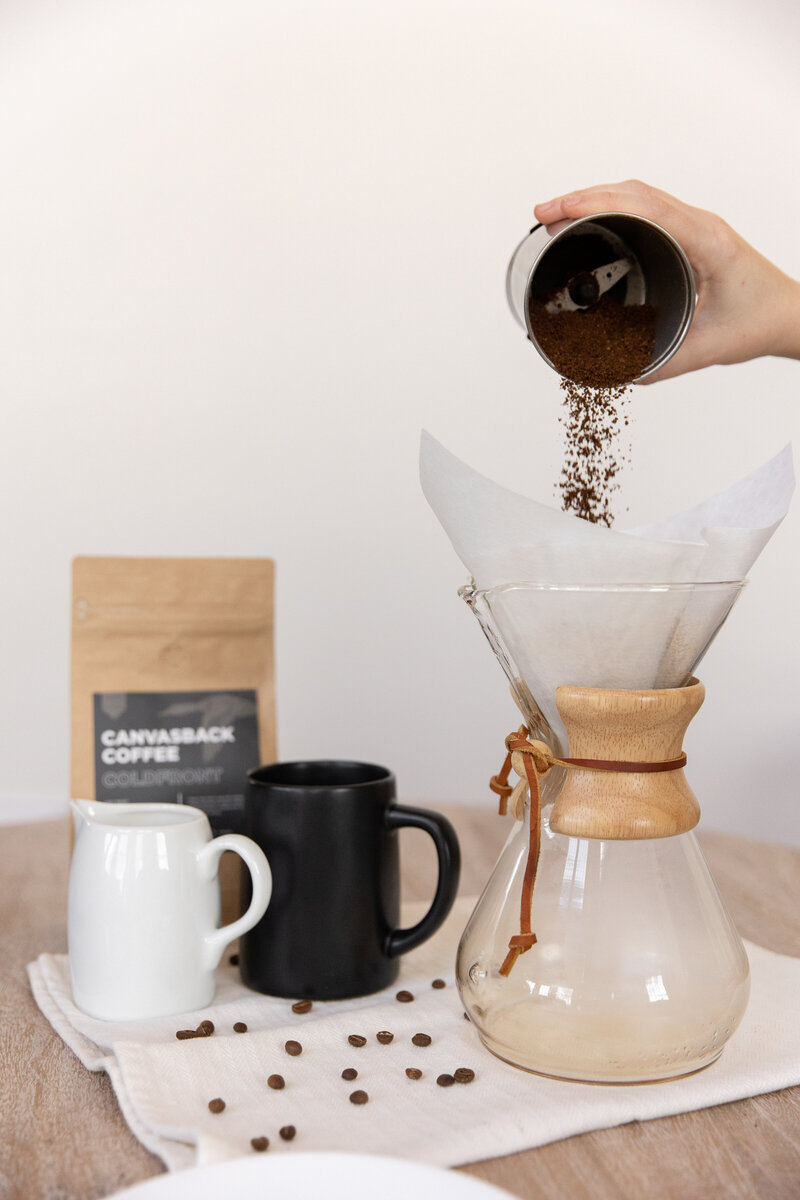 Pouring coffee grounds into Chemex