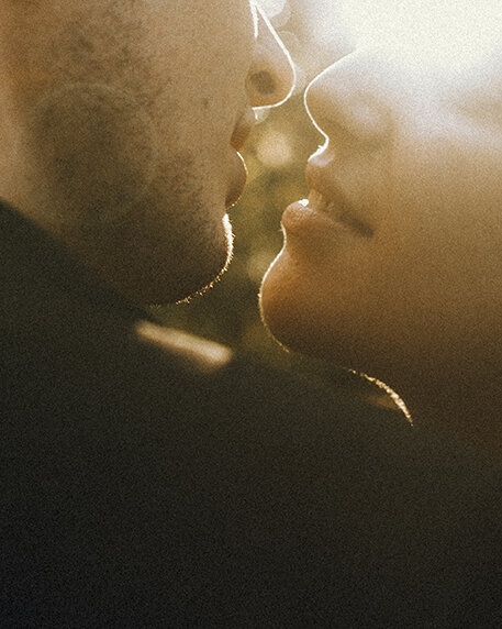 A portrait of a couple just about to kiss with the sun setting behind them. Captured by Eilish Burt Photography in Austria
