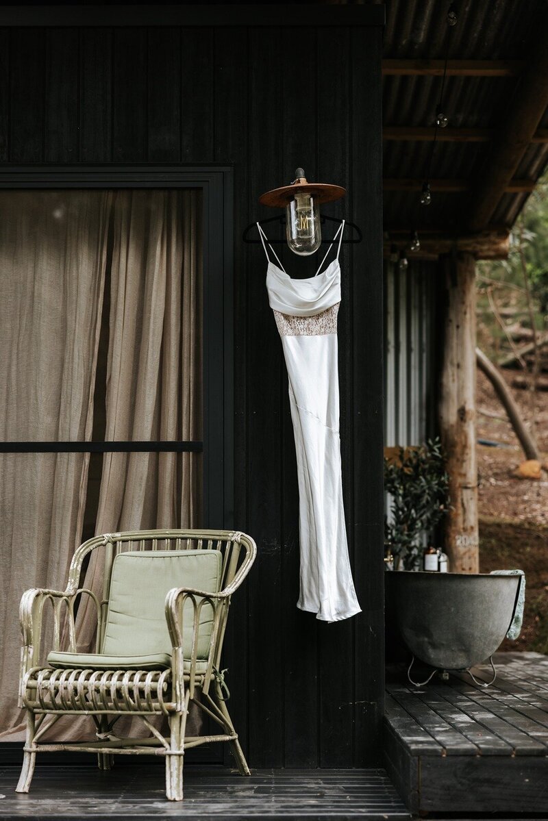 The entrance to a rustic barn with wine barrels out the front