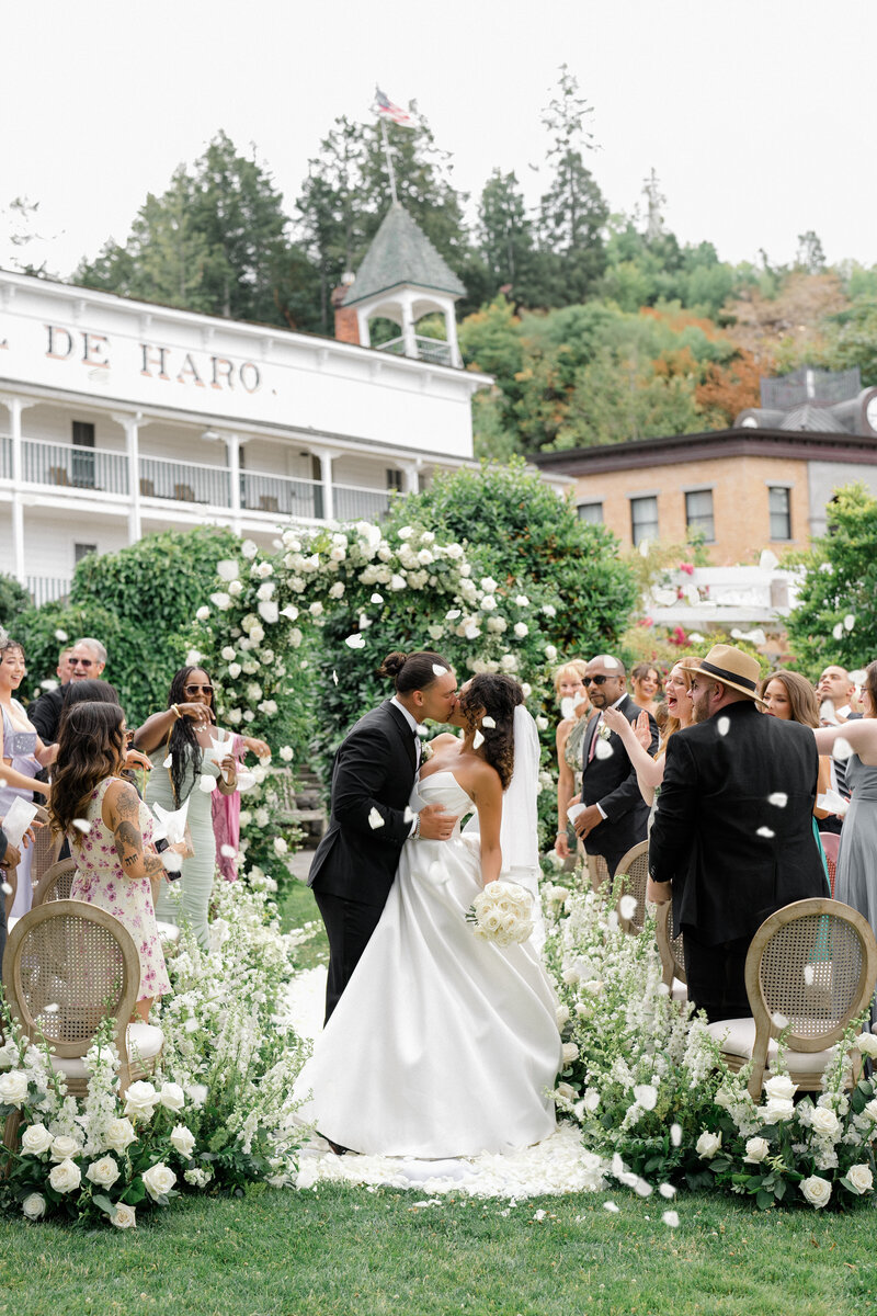 Stunning bride laughs with her bridesmaids on her wedding day while holding floral bouquets