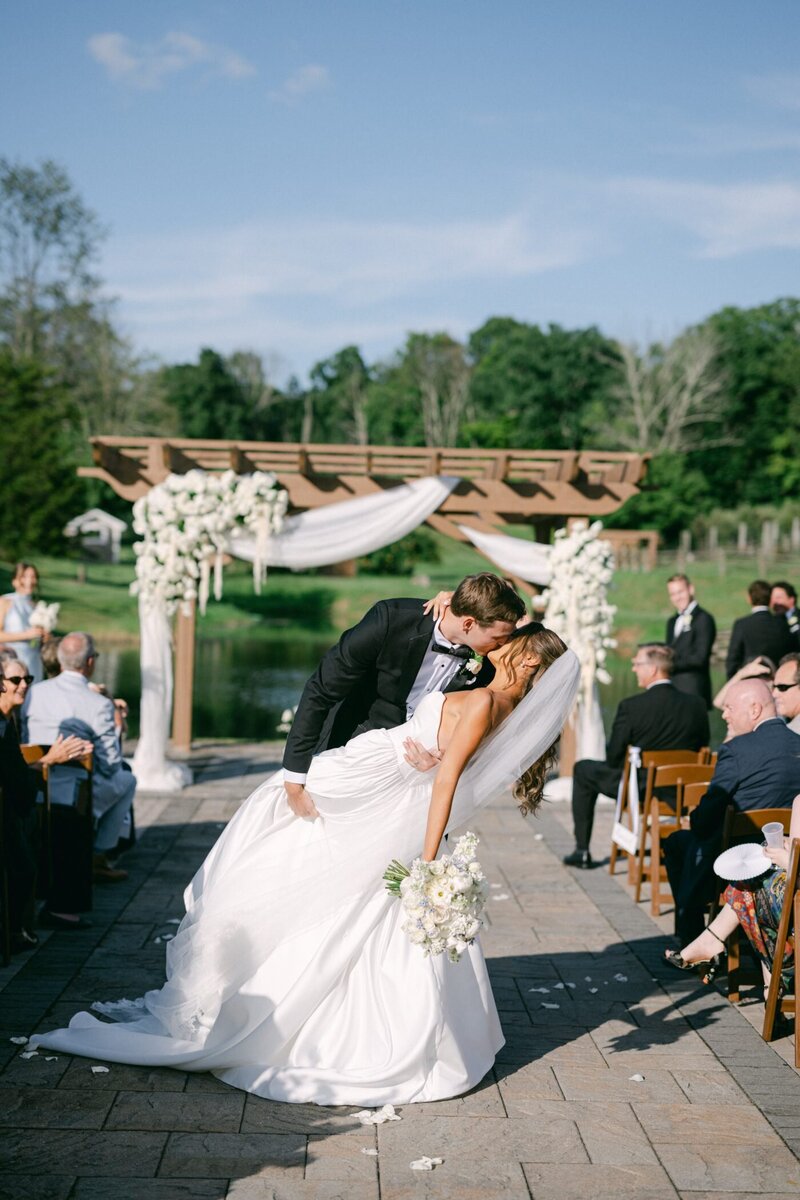 George dipping Anya for a kiss as they walk back down the aisle