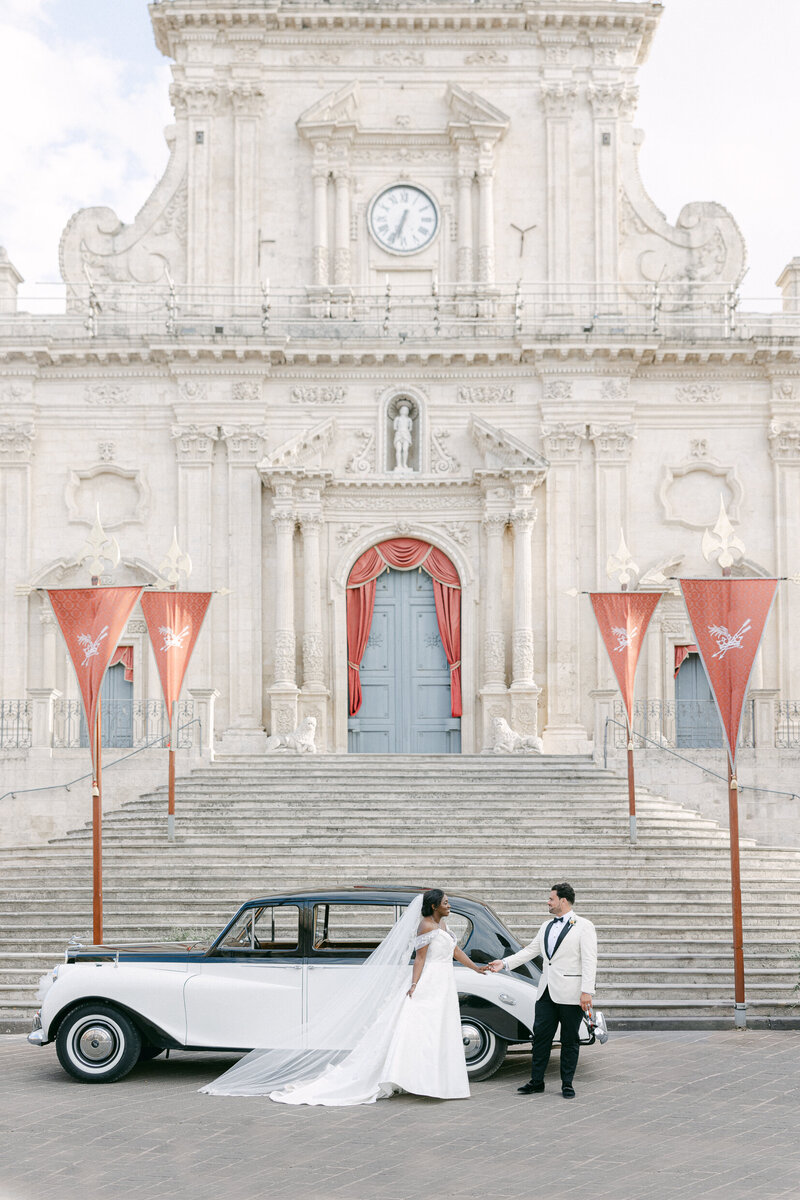 a man helping his bride walk down steps in her wedding dress