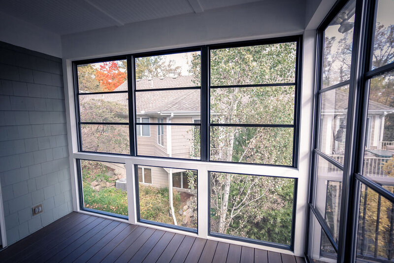 Three-season porch with vinyl windows on the upper portion and custom glass railing on the bottom portion. 