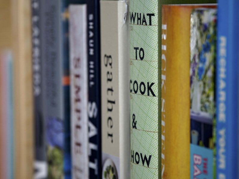 A photograph featuring the spines of cookbooks.