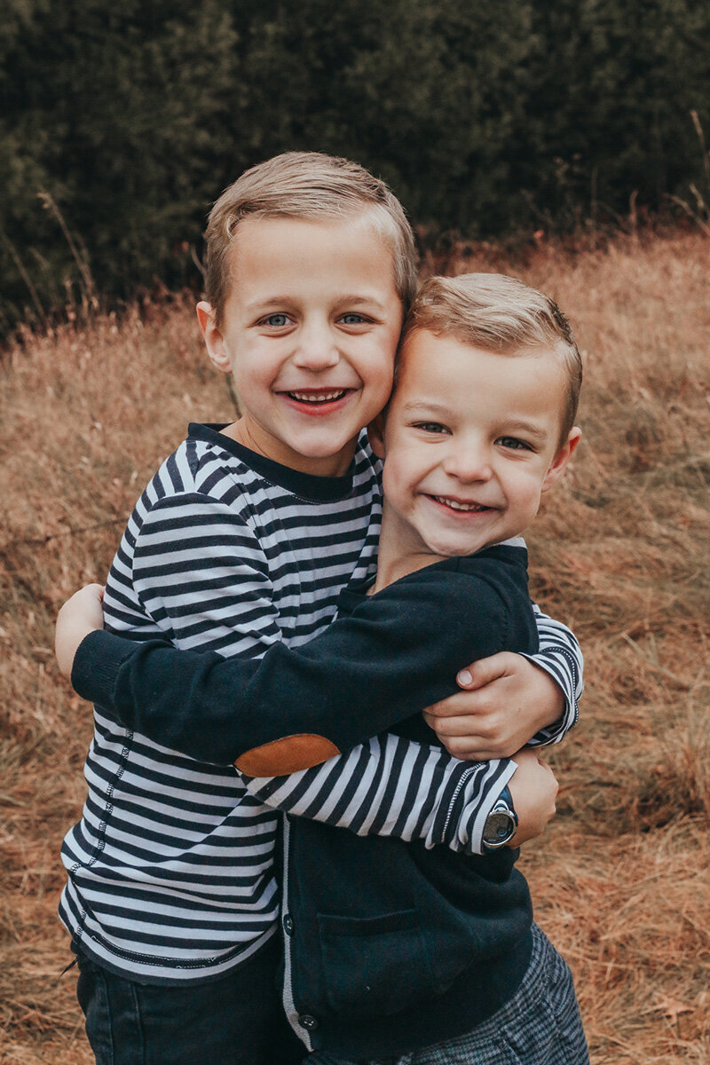 Two brothers hugging each other during family photo session.