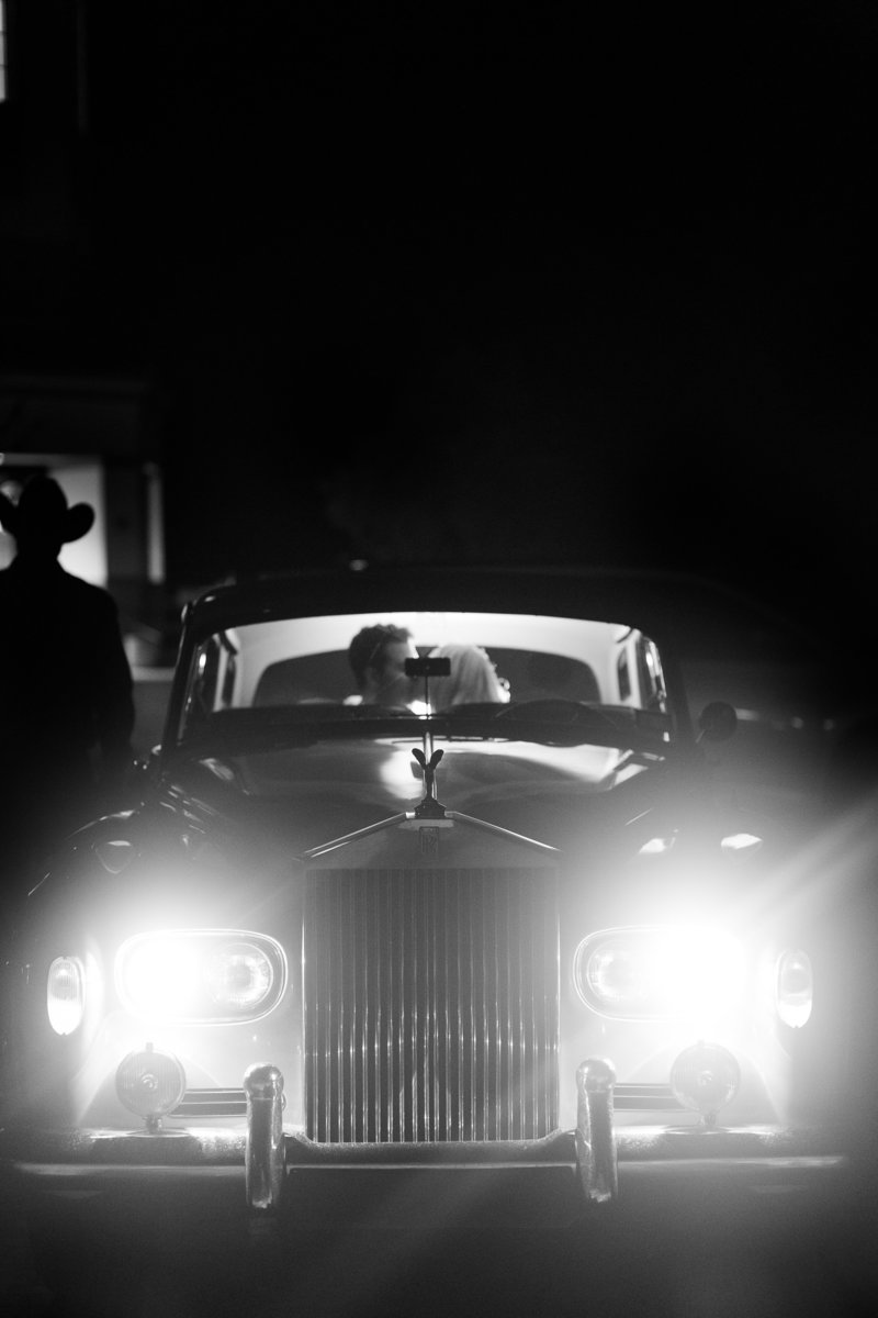 Bride and Groom kissing in the back of a Rolls Royce car