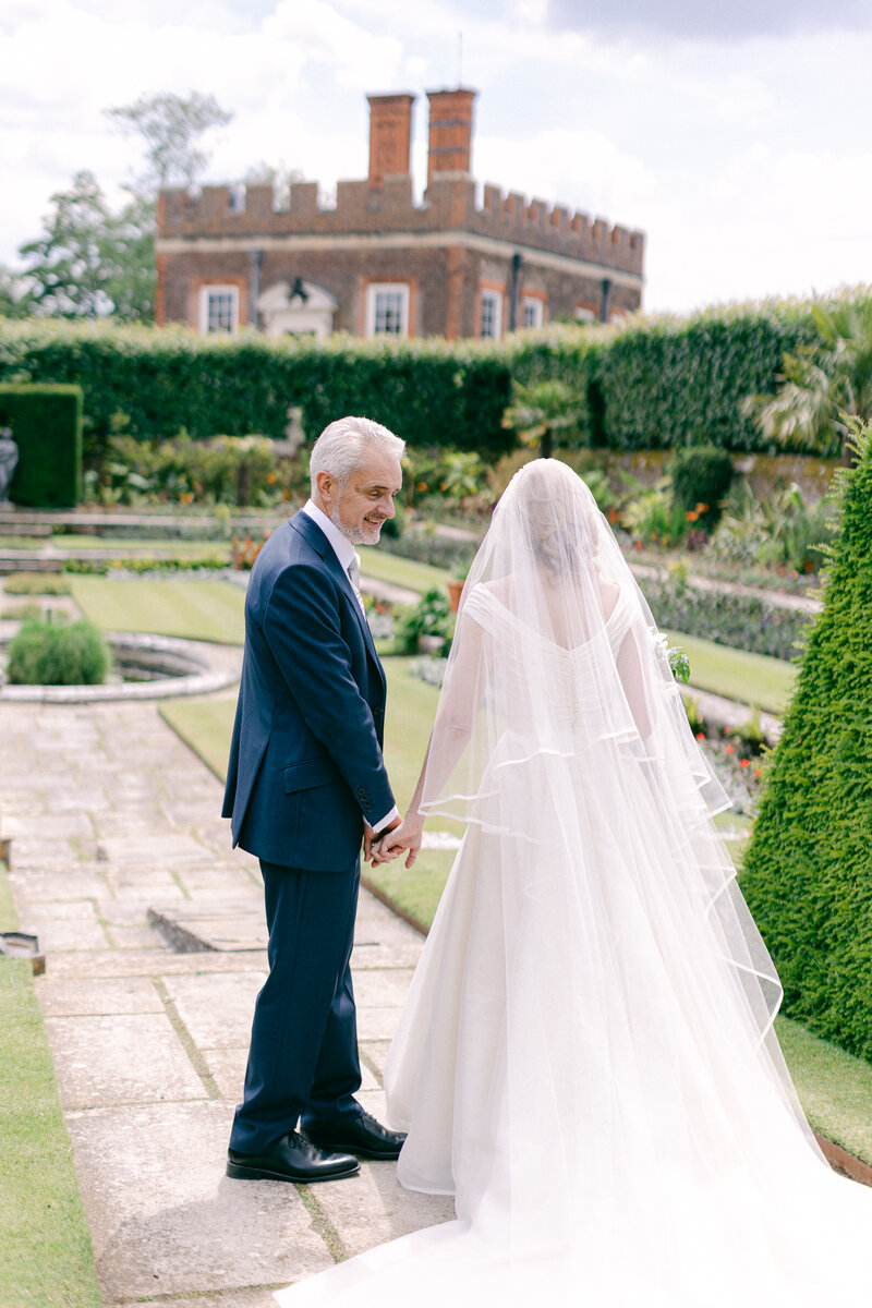 Bride and groom walk to their wedding car at their Hampton Court Palace wedding