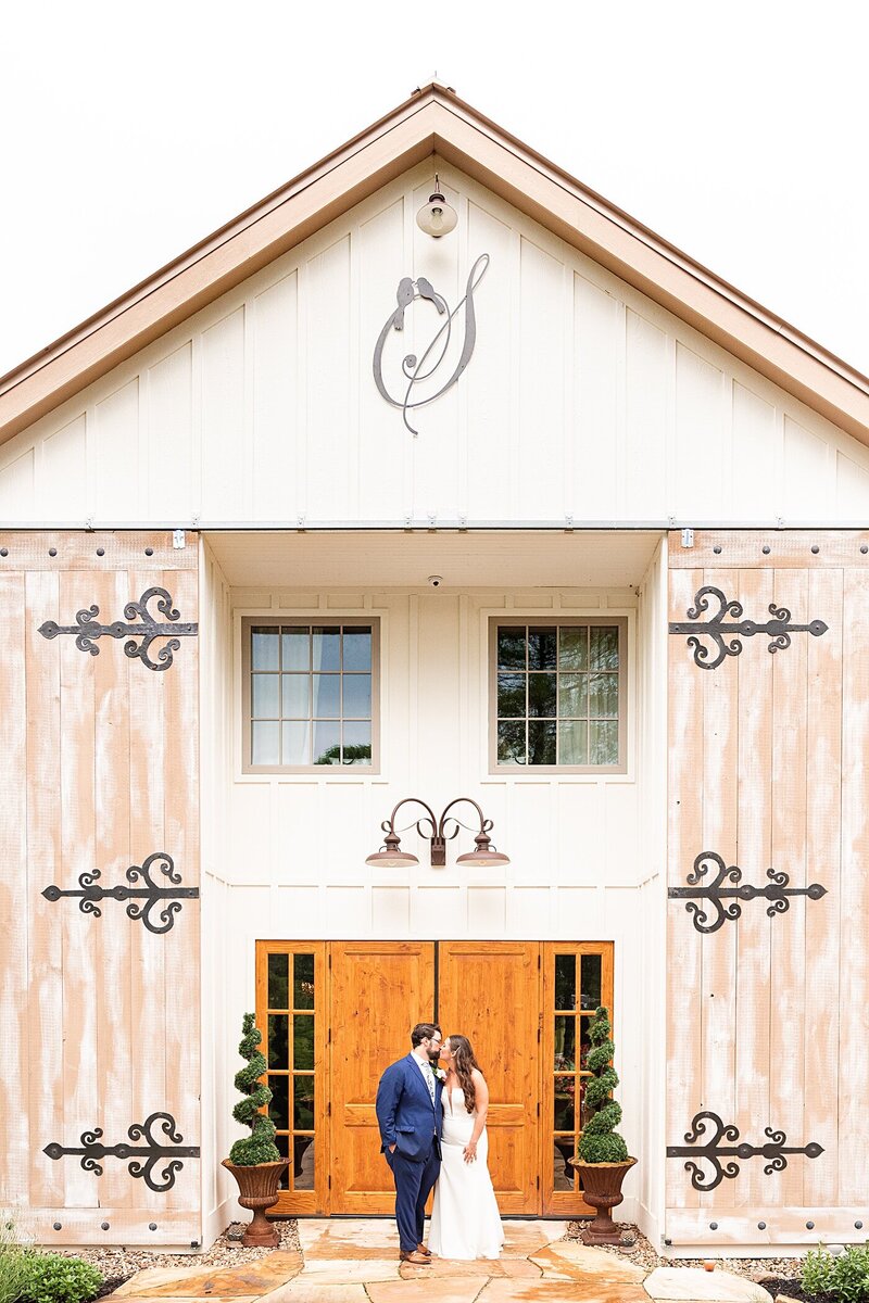 A portrait of the bride and groom standing in front of the doors to The Seclusion in Lexington, Virginia.