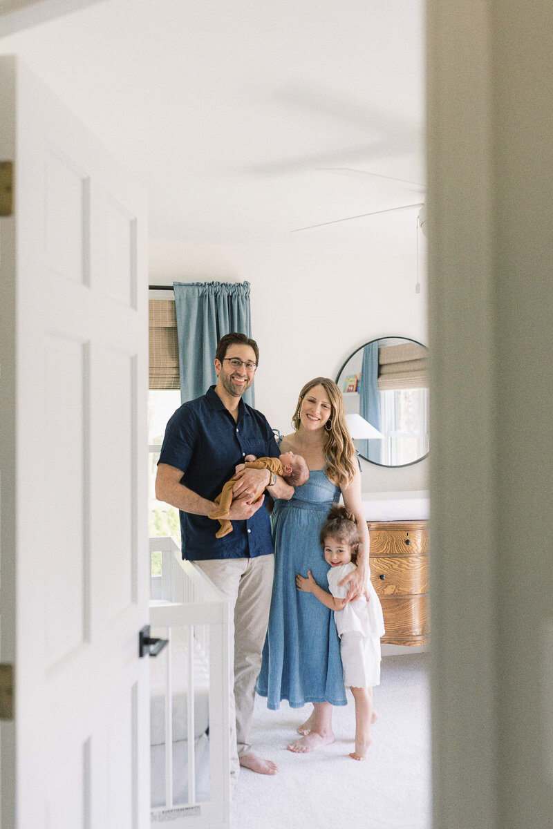 Kaitlin and her husband posing with their newborn and toddler
