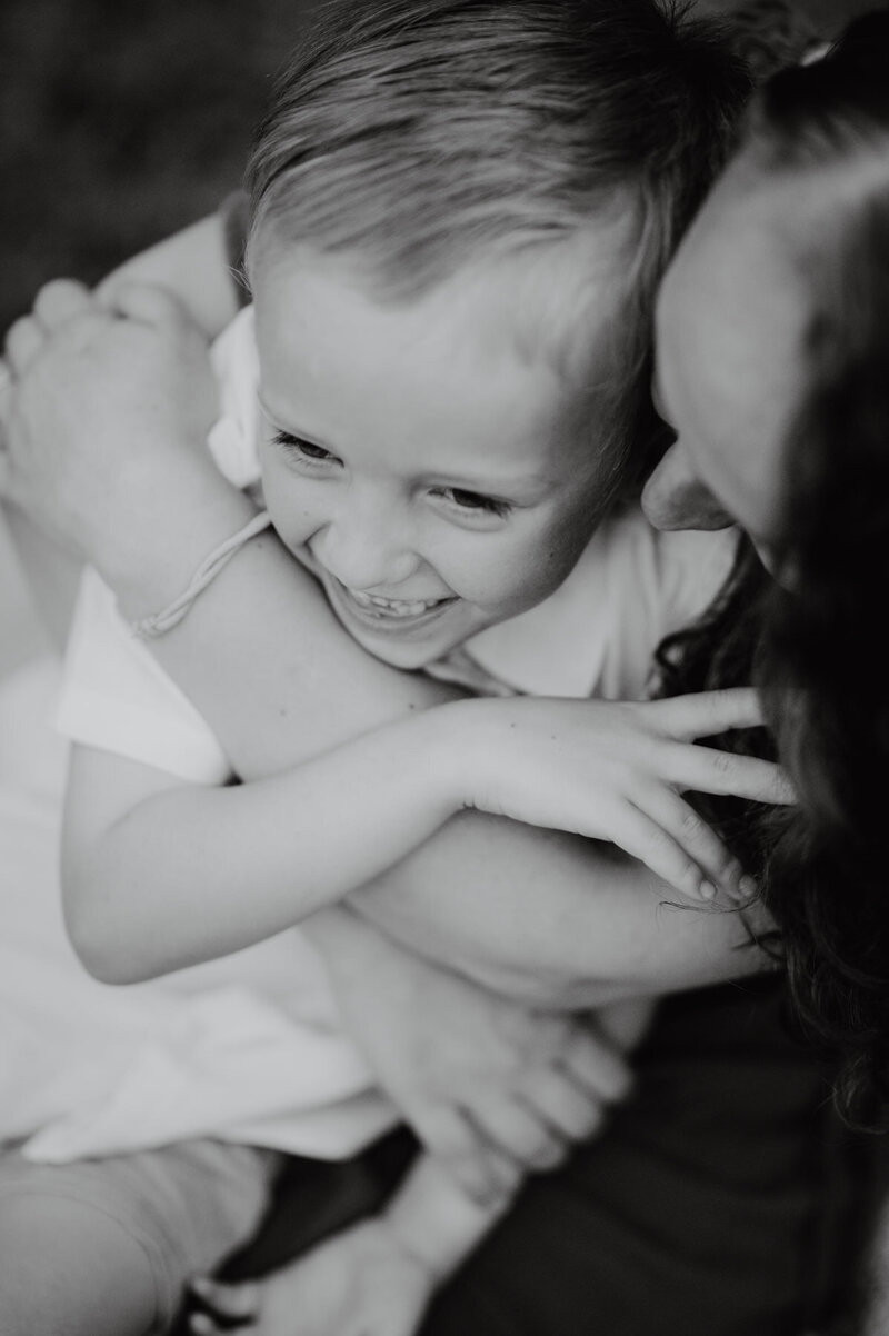 Young boy being cuddled by his mama