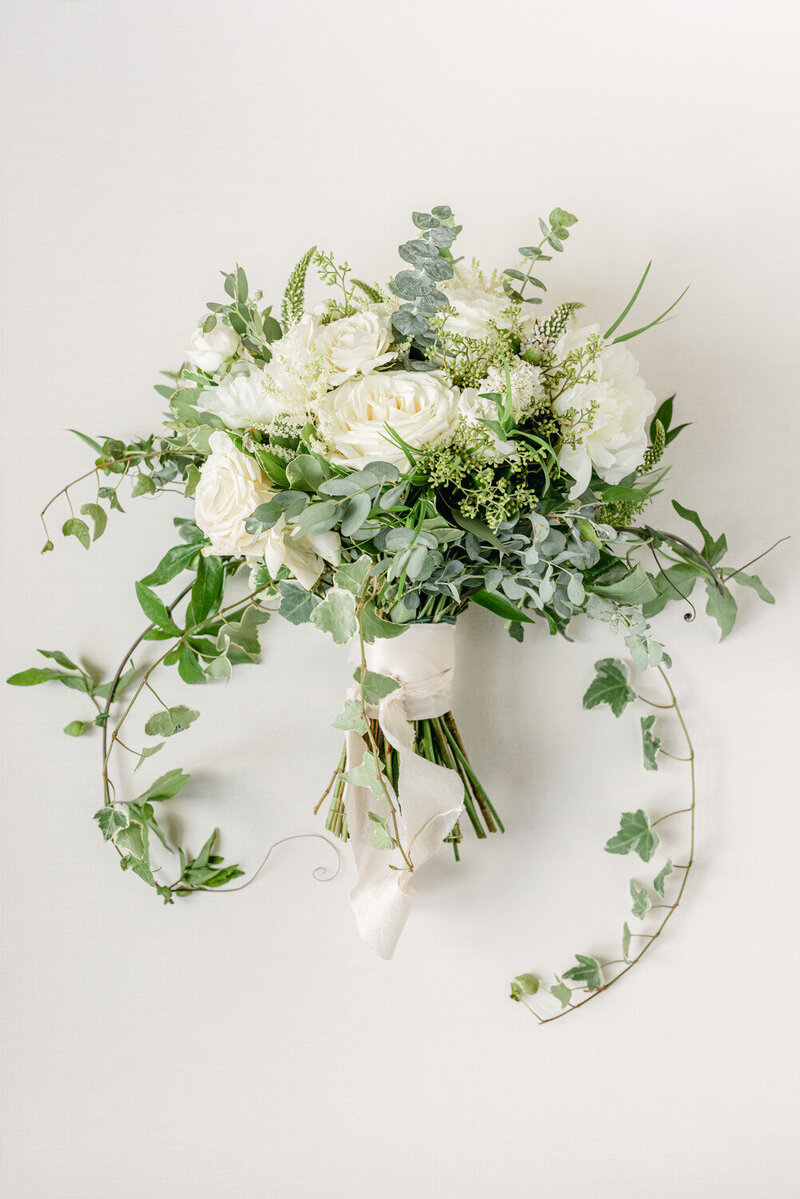 This elegant layflat photograph showcases the bride's bouquet, artfully captured by a Calgary editorial wedding photographer. The arrangement highlights the floral beauty and attention to detail, perfectly reflecting the luxurious and refined nature of the wedding day.