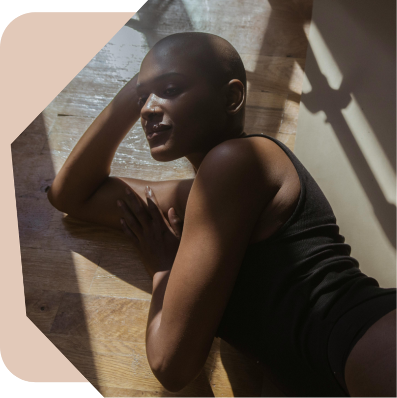 woman in a black tank top laying on wood floor