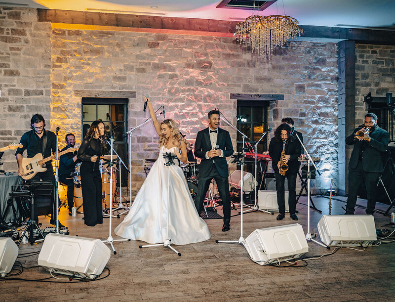 Bride and groom sing with the band for live band karaoke performance at their wedding