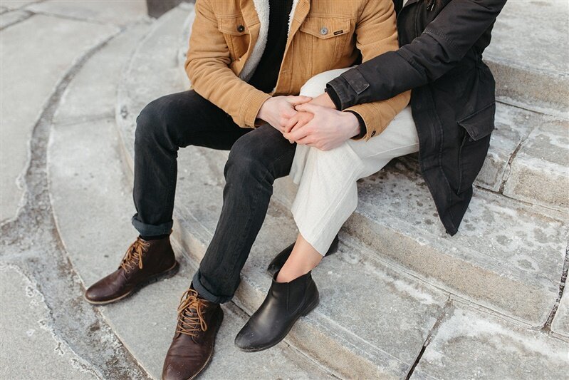 couple sitting on city step holding hands