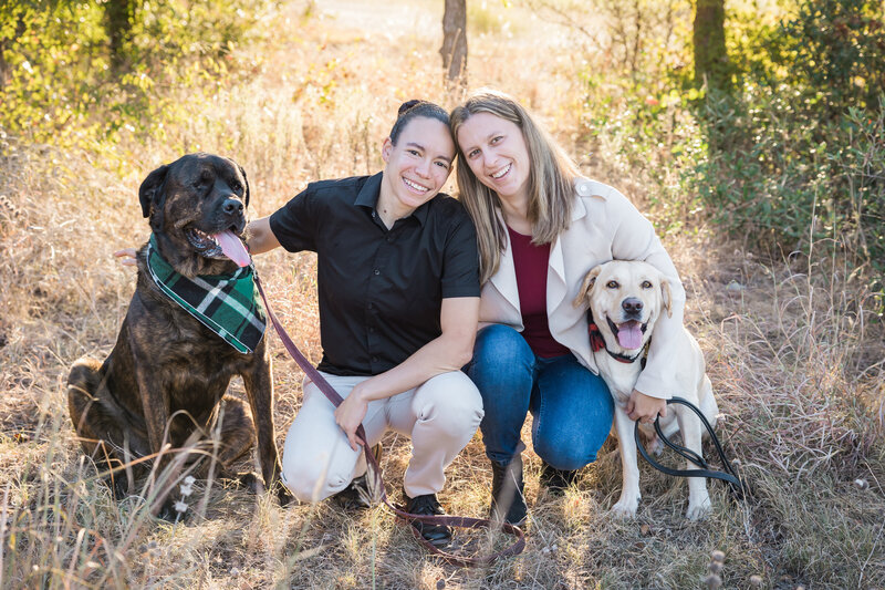 same sex couple posing with their dogs