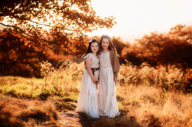 Sisters embrace during Fall Family Photos in Asheville, NC.