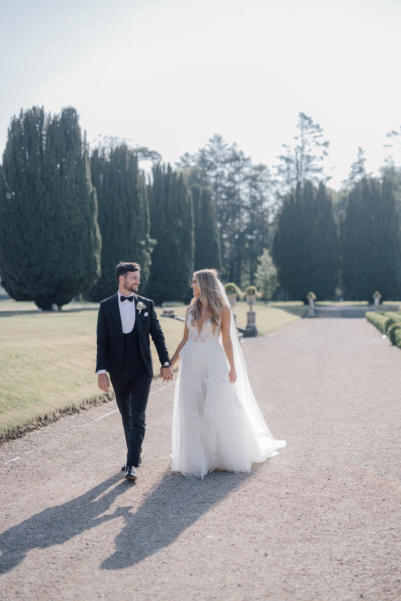 bride-and-groom-walking-in-formal-gardens-at-castlemartyr