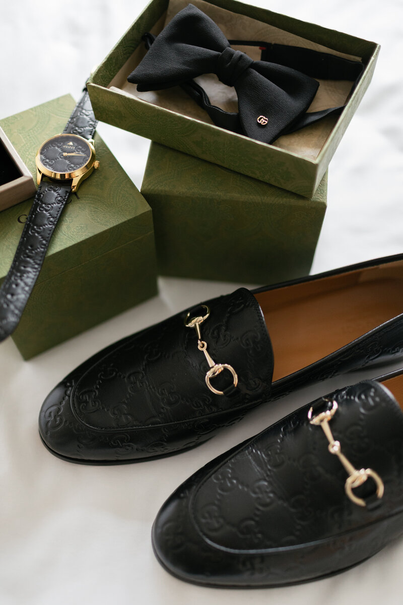 flat lay of bride's getting ready items with gucci loafers, gucci watch, and gucci bow tie