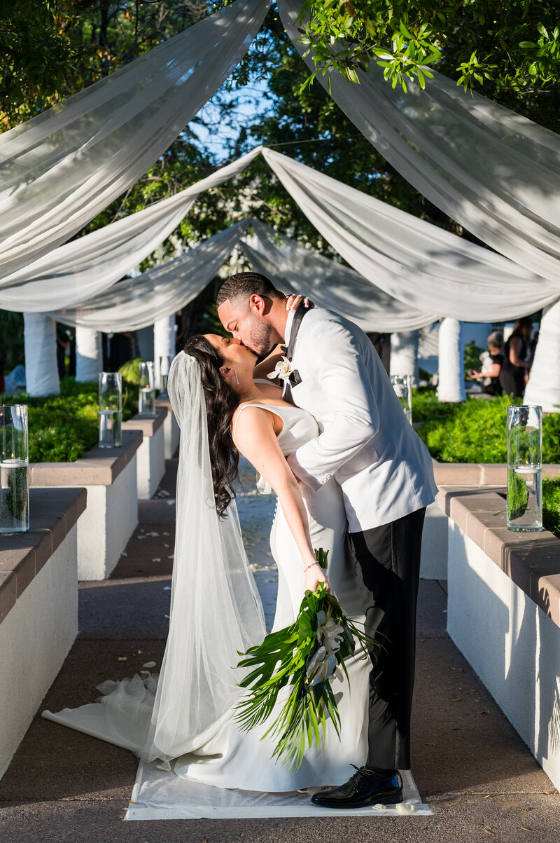 Bride and groom sharing a romantic moment by the pond at Emerald at Queensridge.