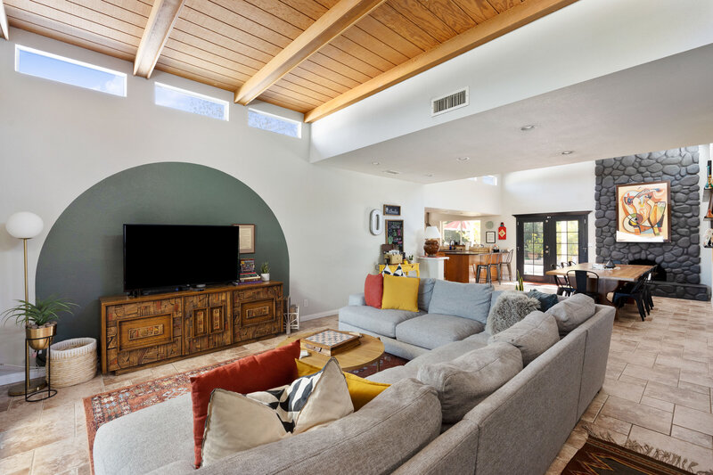 A mid-century inspired living room with wood ceilings, clerestory windows, and a brutalist credenza.