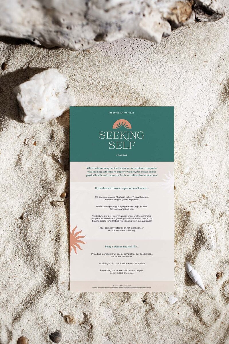 Mock-up of teal and orange graphic design handout on sandy surface.