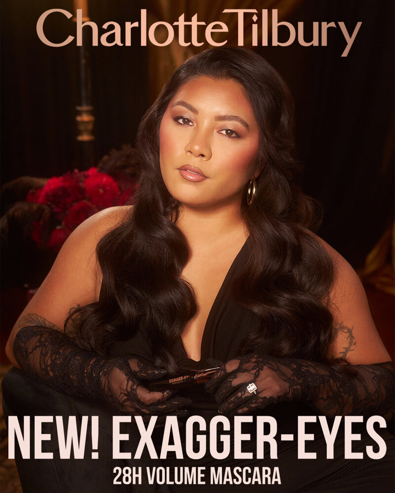 Charlotte Tilbury Exagger-Eyes 28H Volume Mascara campaign featuring Riyah Taylor, styled with long waves and glamorous makeup in an elegant setting.