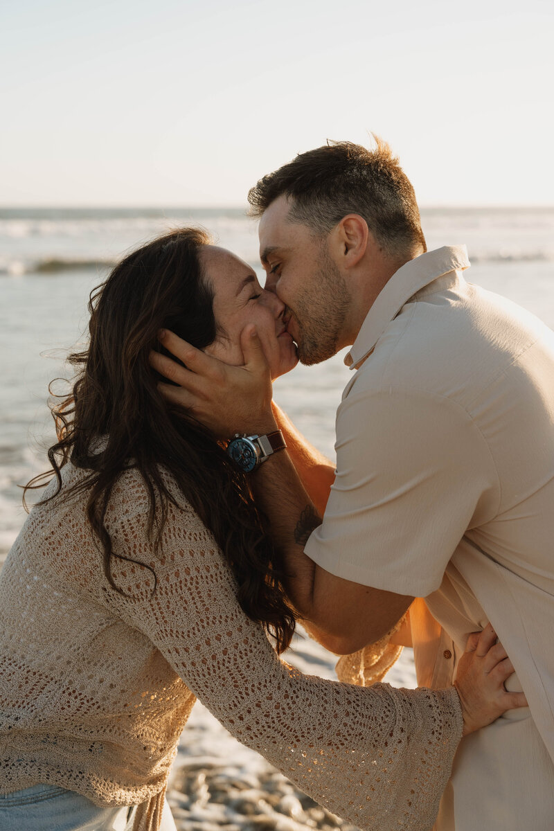 a man kissing a woman and her trying to push him away laughing