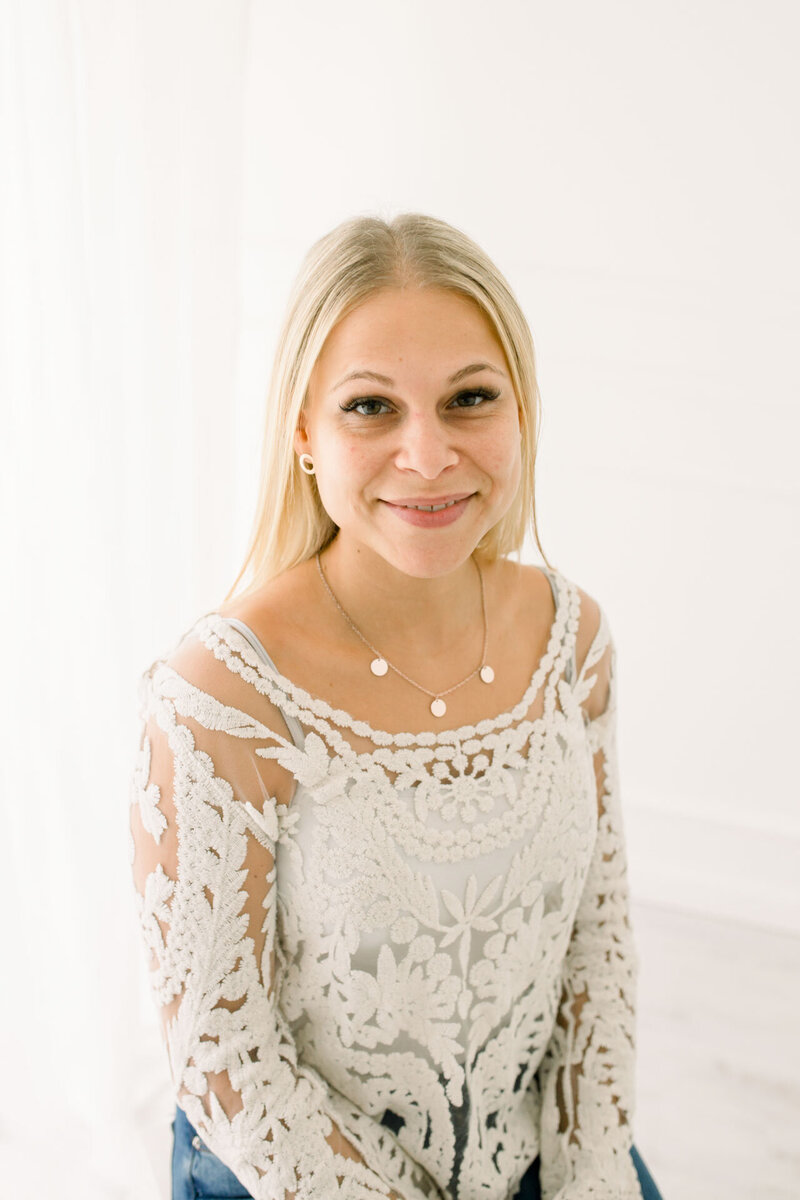 Blonde Frau im weißen Spitzenoberteil vor dem Styling für das Fotoshooting im Fotostudio Gütersloh bei Bielefeld.