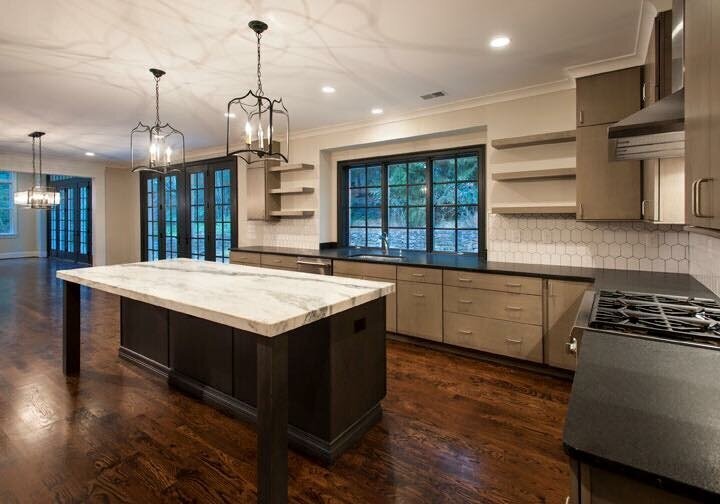 A kitchen remodel featuring gorgeous hardwood floors, a large eat-in island, and open concept shelving provides a gathering space in the heart of the home.