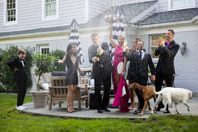 Celebration with spraying champagne as dogs run wild.