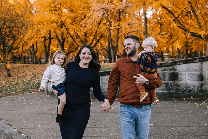 Family of four walking through Allegheny Commons Park. 
