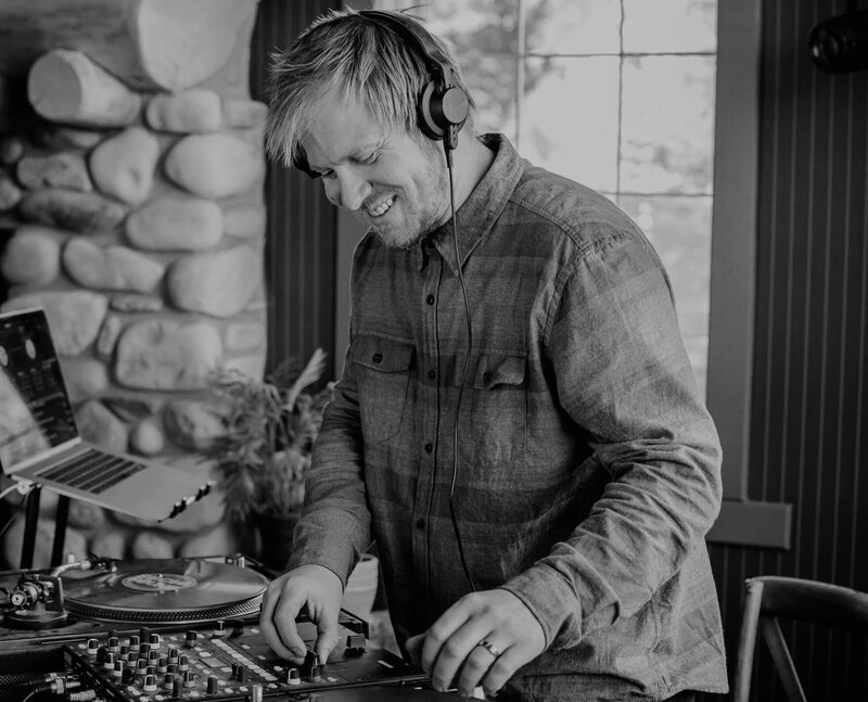 Bride and groom embracing at golden hour in Canmore, surrounded by forest and mountain rock, with a warm-toned bouquet and soft sunset lighting.