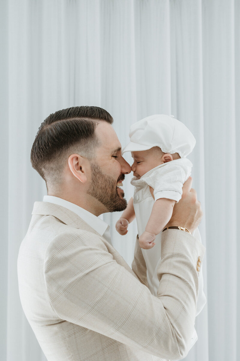 Smiling baby dressed in white for a baptism in Perth