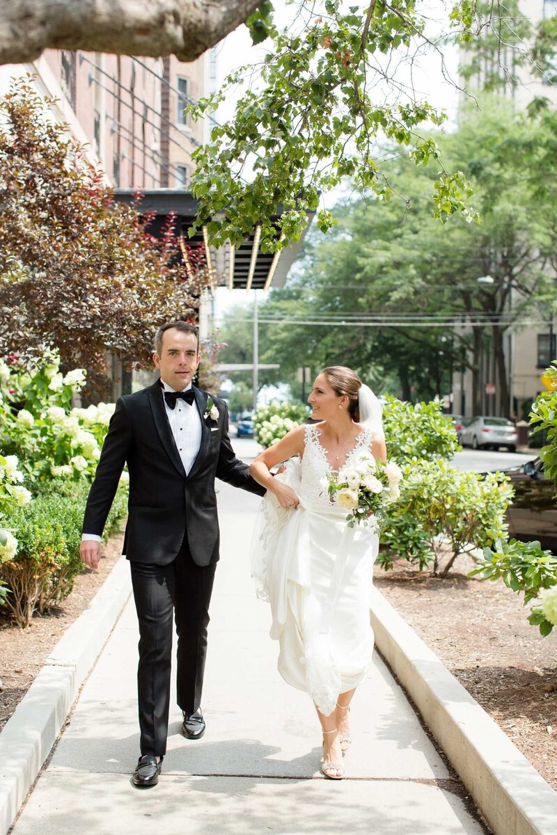 Outdoor City Street Bridal Portrait of Bride and Groom Walking at a Luxury Summer Wedding