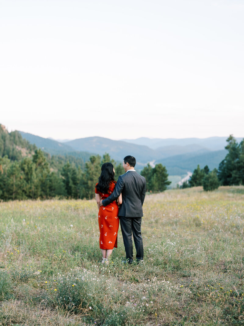 Couple holding hands behind a backdrop of a mountain in Colorado by Colorado Wedding Photographer JKG Photography