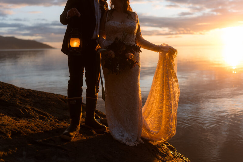 bride and groom walking on beach with lanters Alaska Adventure Elopement