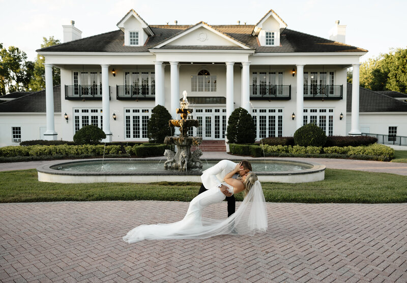 Couple dip kiss in front of Luxmore Estate Venue