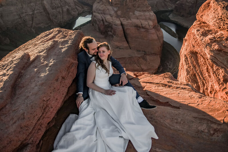 A couple sharing a quiet moment after eloping at Horseshoe Bend, with the stunning rock formations and Colorado River as their backdrop.