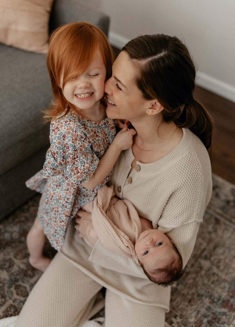 Mackenzie Romagni shares a sweet moment with her child and newborn, beautifully captured by a Cleveland newborn photographer.
