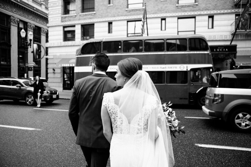 Real bride wearing a veil and walking with her groom in downtown Portland