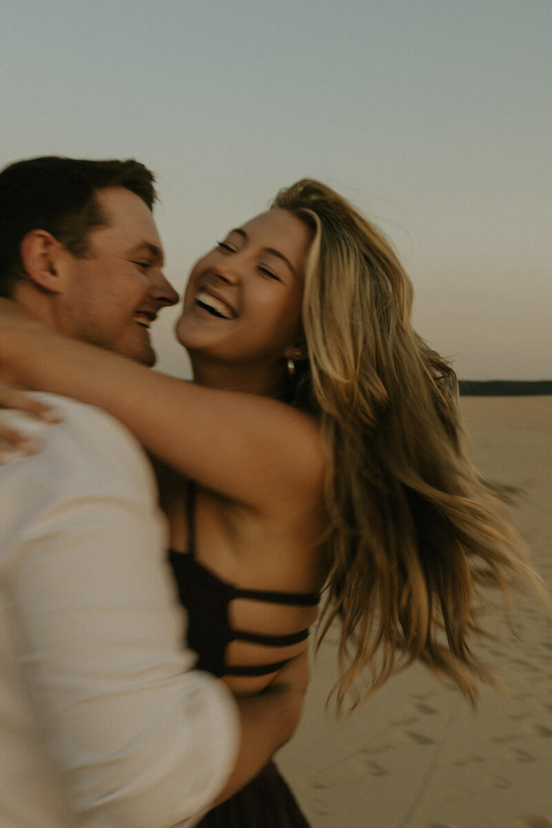Adventurous engagement photos at Silver Lake Sand Dunes in Michigan.