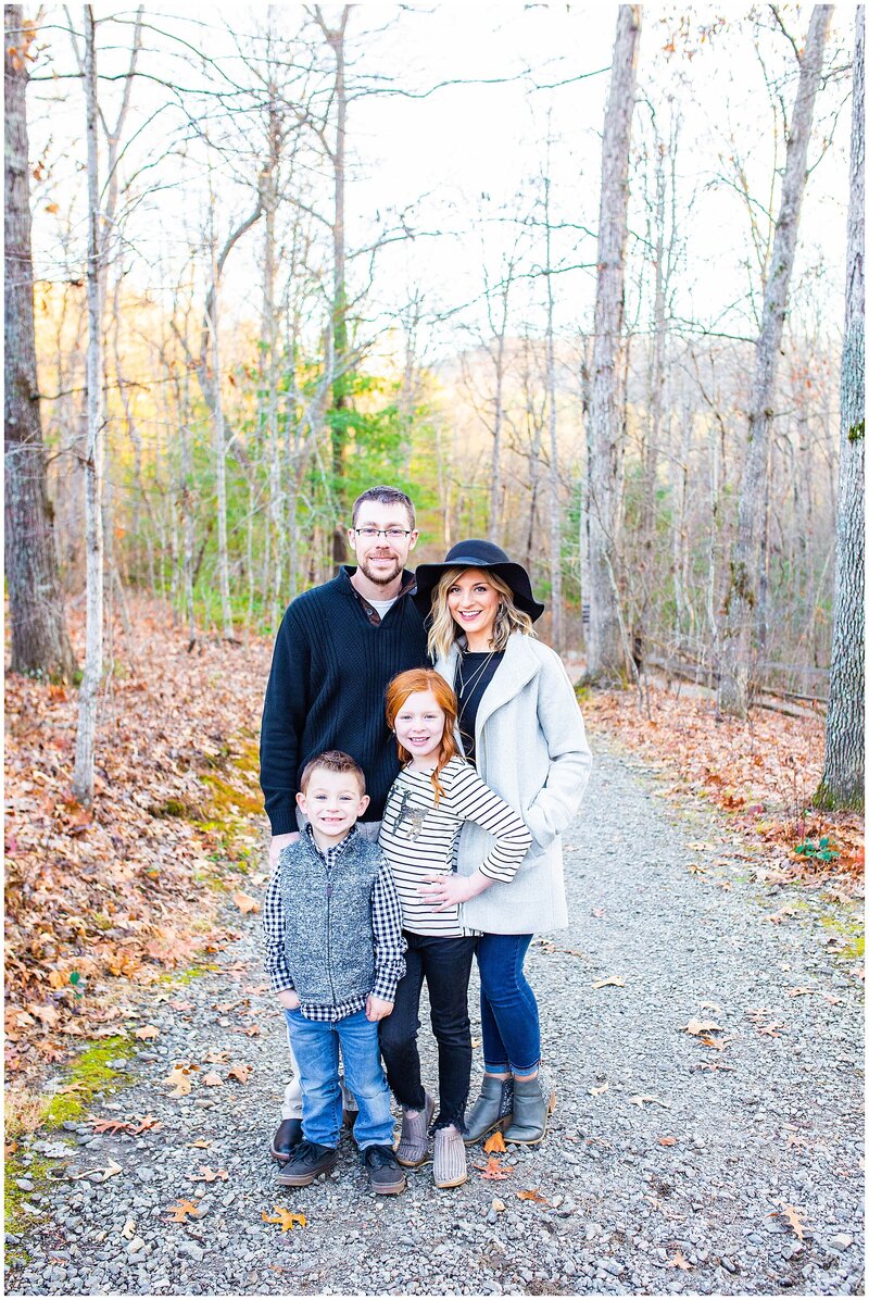 family of 4 with fall outfits on in forest