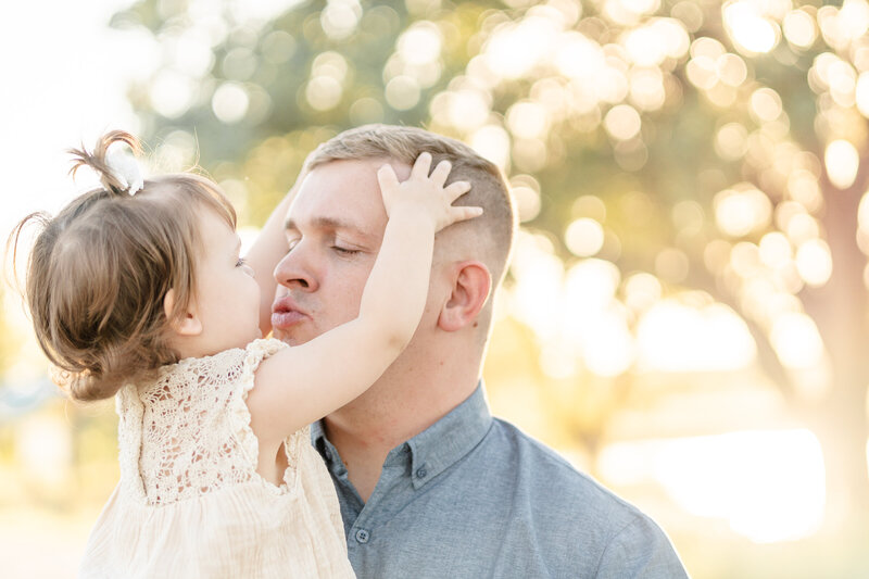 father and toddler kisses