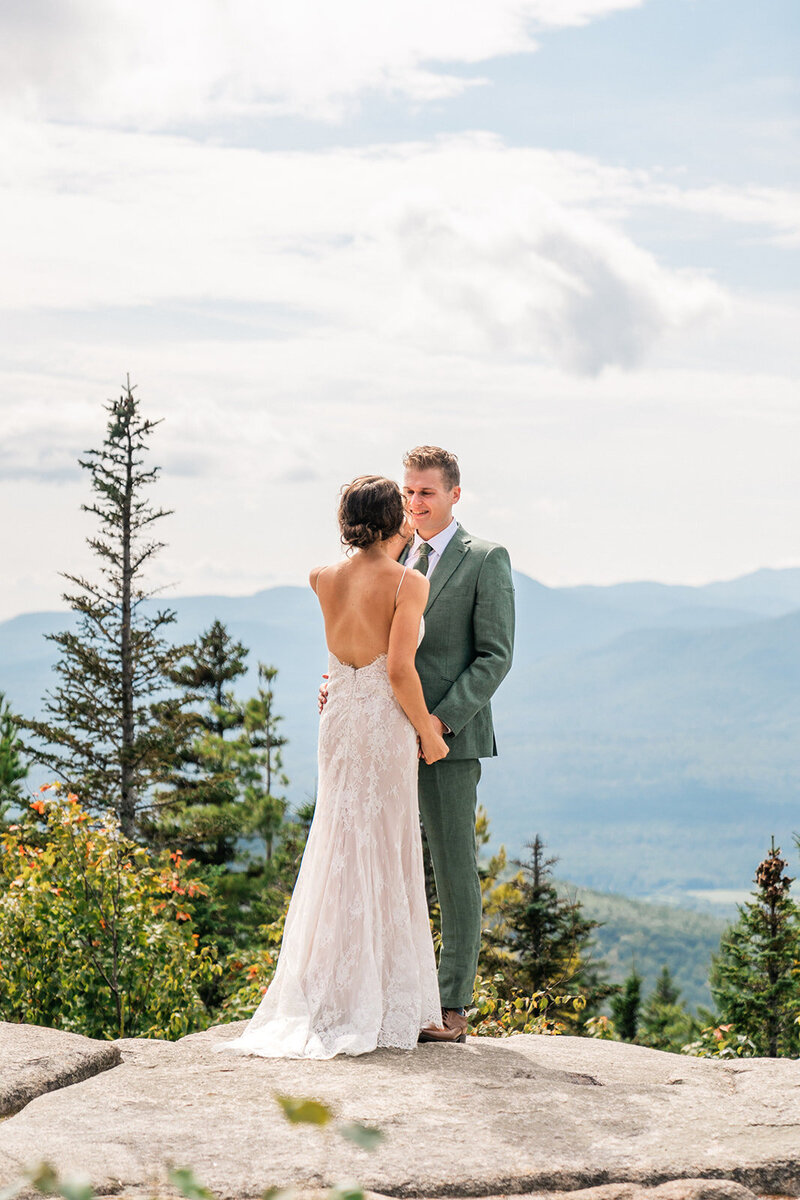 A couple standing on the summit of a mountain during their Maine elopement. 